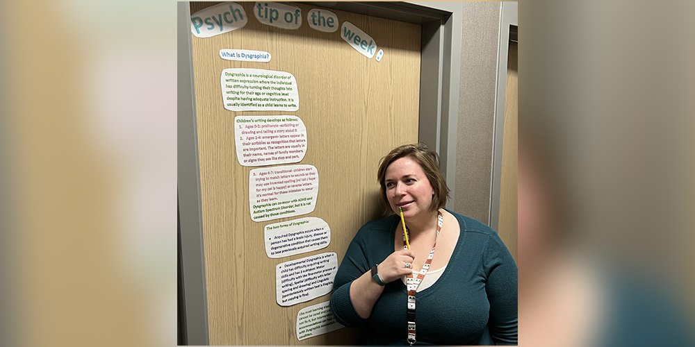 Mrs. Rollins in front of the psych tip displayed on her office door.