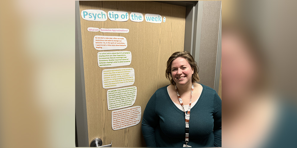 Mrs. Rollins in front of the psych tip posted to her door.