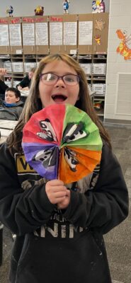 Student holding fan from art class