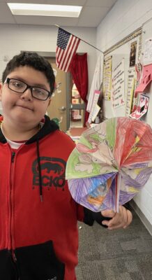 Student holding fan from art class