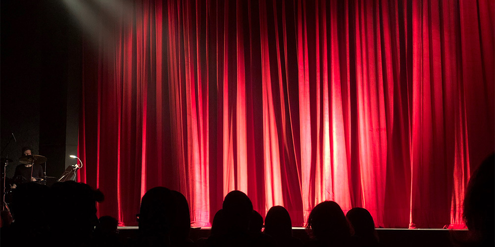 red curtains opening on a theatre