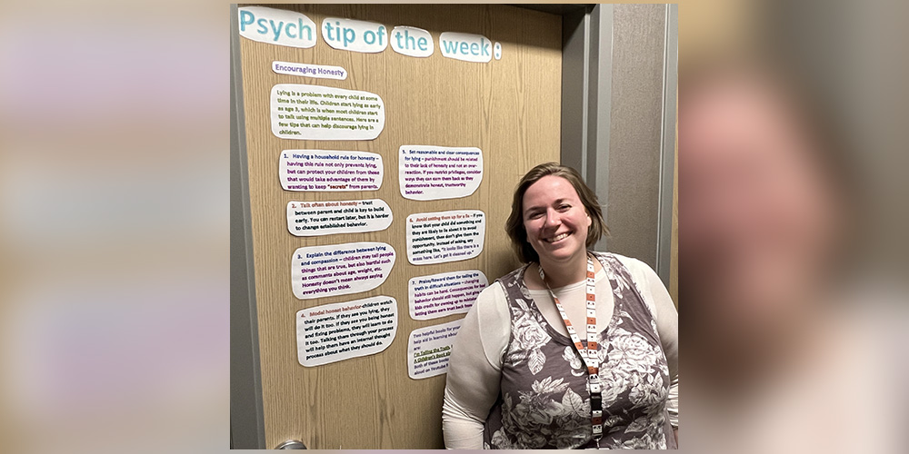 Mrs. Rollins in front of the psych tip posted on her office door