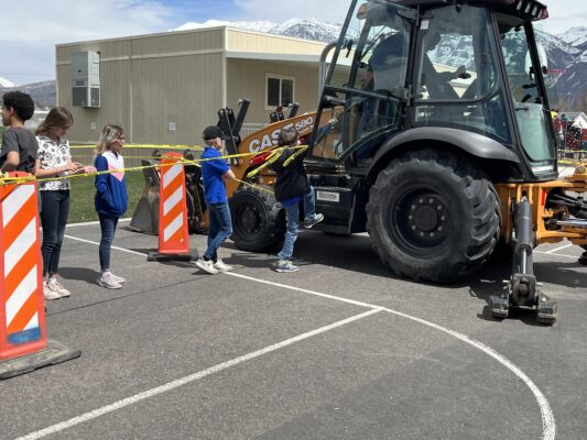 Students using machinery from Provo City Public Works