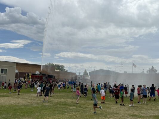 Students play water games on the field for field day