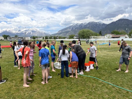 Students play water games on the field for field day
